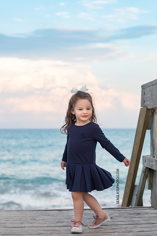 Young girl on the boardwalk during family photos in Vero Beach Florida