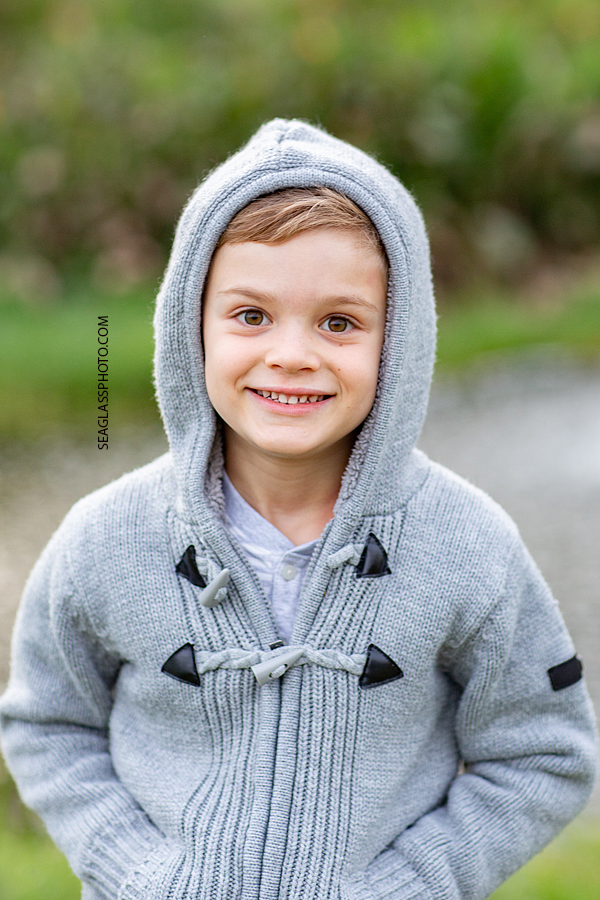 Close up of young boy cheesing for the camera during family photos at the Country Club in Vero Beach Florida