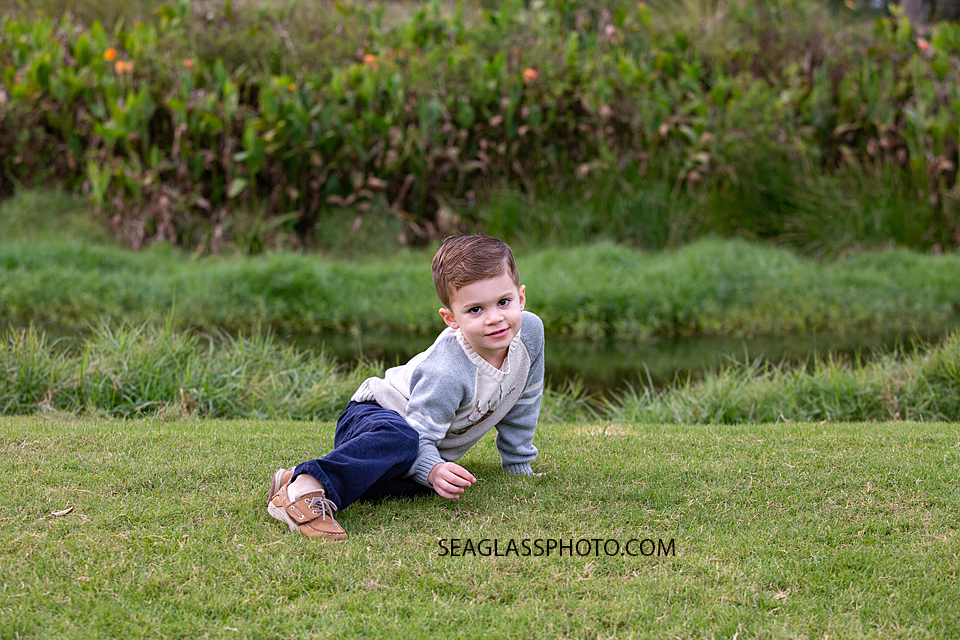 Little boy cheesing for the camera during family photos at the Country Club in Vero Beach Florida