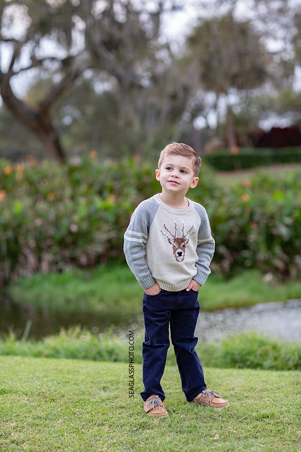 Young boy poses and looks off in the distance during family photos at the Country Club in Vero Beach Florida