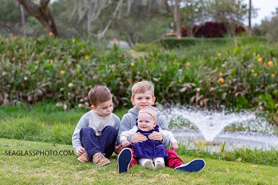 Big Brothers hold their little sister during family photos at the Country Club in Vero Beach Florida