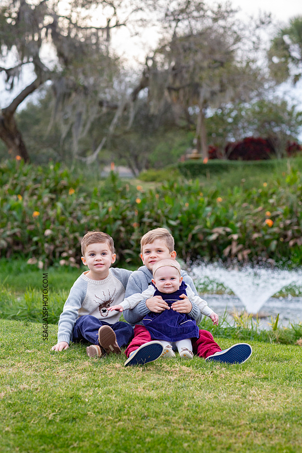 Big brothers holding their little sister during family photos at the Country Club in Vero Beach Florida