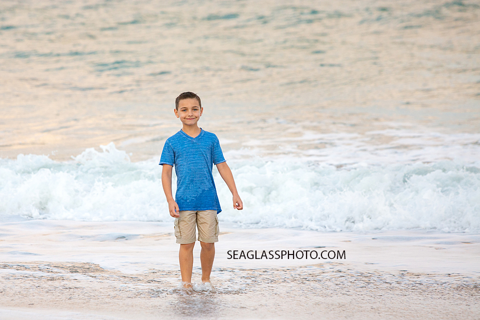 Young boy in the water on the beach during their family photoshoot in Vero Beach Florida
