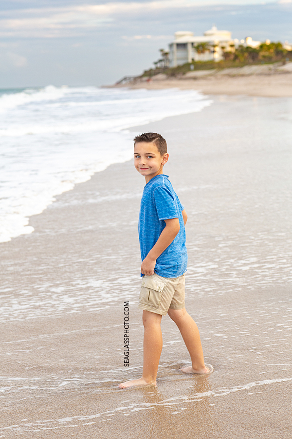 Young boy walks on the beach during their family photoshoot in Vero Beach Florida