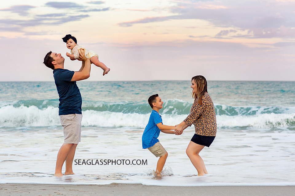 Family plays in the water on the beach during their family photoshoot in Vero Beach Florida