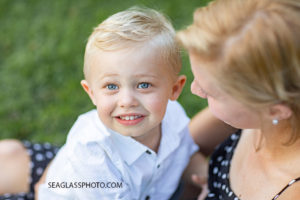 Close up of mother and son sitting in the grass during family photos at Riverside in Vero Beach Florida