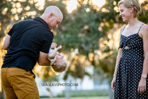 Father plays with his son while mom smiles during family photos at Riverside in Vero Beach Florida