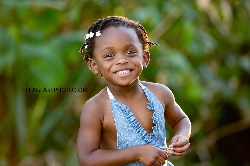 Close up of young girl smiling while wondering the garden during family photos in Vero Beach Florida