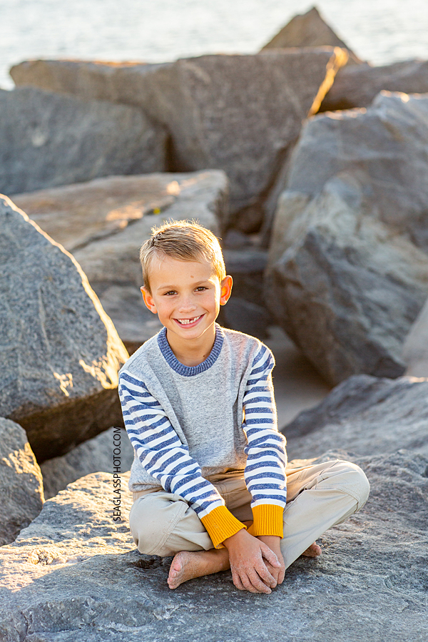 Young boy sitting on the rocks at the Fort Pierce Inlet during family photos
