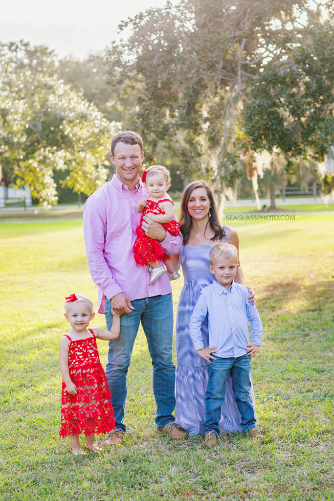 Family smiles for a picture standing up during family photos at Riverside in Vero Beach Florida