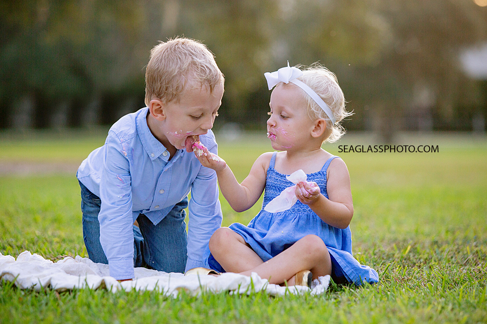 Little sister feeds her big brother some cake during family photos at Riverside in Vero Beach Florida