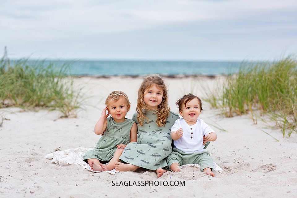 Cousins sit on the beach during family photos in Vero Beach Florida