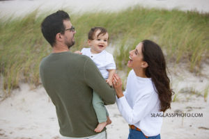 Family of three smile on the beach during family photos in Vero Beach Florida