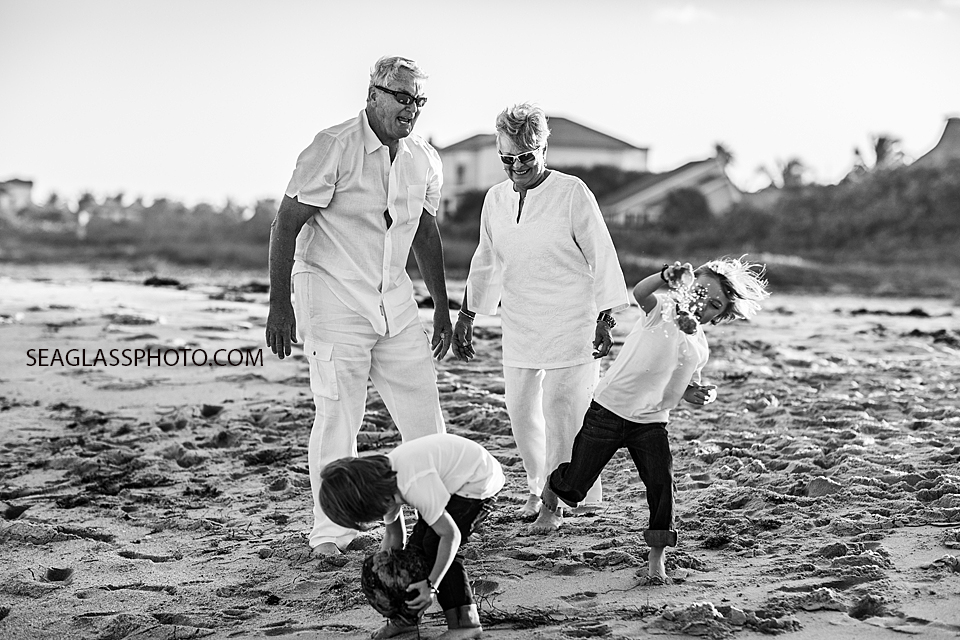 Black and white photo of grandparents playing with their grandsons on the beach during family photoshoot in Vero Beach Florida