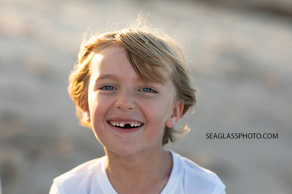 Close up of young boy who recently lost his front tooth during family photoshoot in Vero Beach Florida