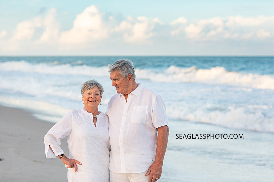 Husband looks at his wife happy as can be on the beach during family photoshoot in Vero Beach Florida