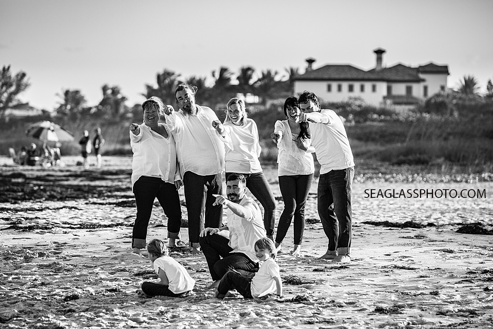 Black and white photo of family pointing towards the ocean during family photoshoot in Vero Beach Florida