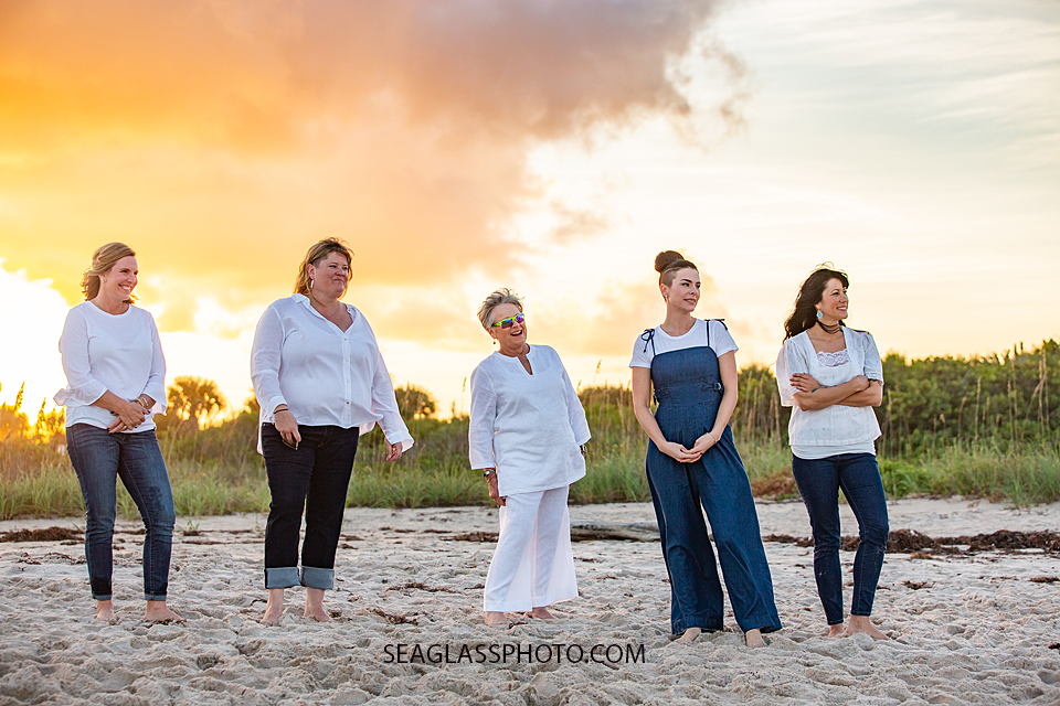 The girls in the family all looking at their wonderful families playing on the beach during family photoshoot in Vero Beach Florida