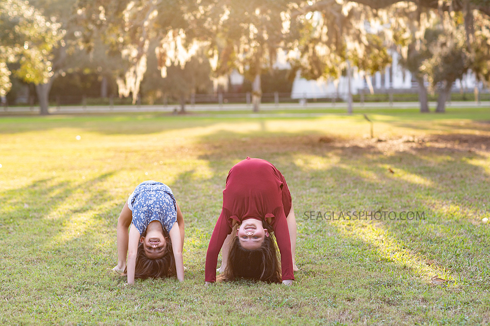 Sisters do a back hand spring together during sister photoshoot in Vero Beach Florida