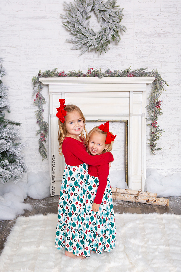 Sisters hug during Christmas photoshoot in Vero Beach Florida
