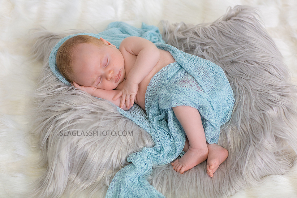 Newborn baby boy swaddled in blue during newborn photoshoot in Vero beach Florida