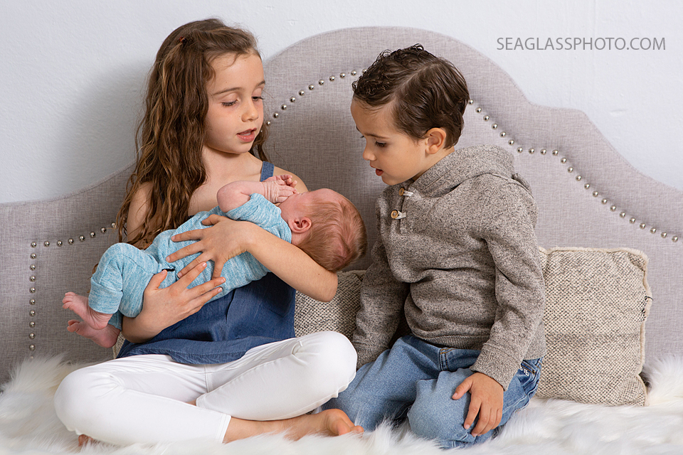 Siblings hold their new little brother during newborn photoshoot in Vero beach Florida
