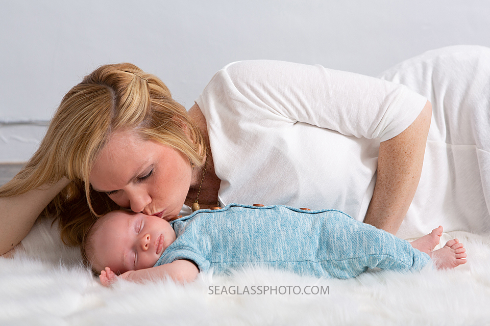 Mom kisses her new son on the forehead during newborn photoshoot in Vero beach Florida