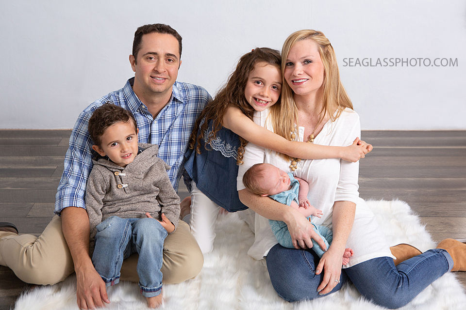 Family amiles for the camera during newborn photoshoot in Vero beach Florida