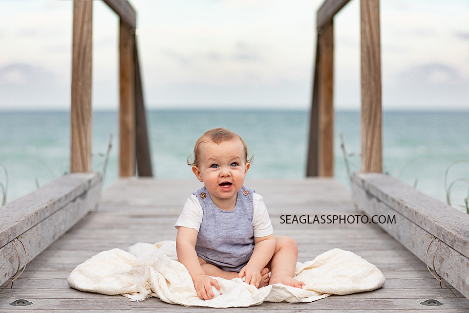 Young boy sits on the board walk during family photos in Vero Beach Florida