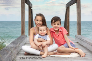 Siblings sit on the board walk during family photos in Vero Beach Florida