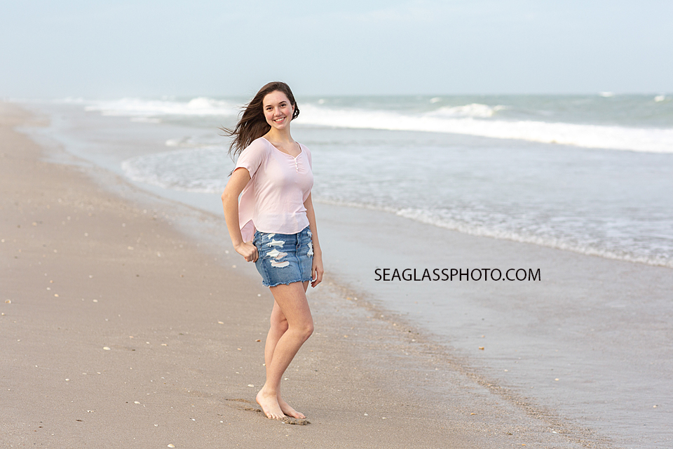 Young lady poses by the water during family photoshoot on the beach in Vero Beach Florida