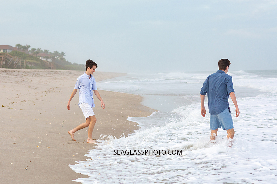 Brothers playing with the water during family photoshoot on the on the beach in Vero Beach Florida