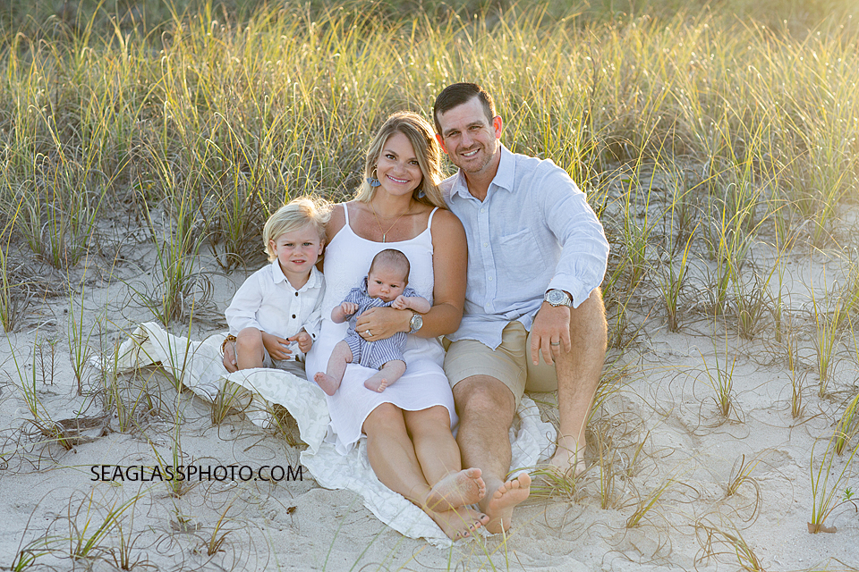 Family sits in the dunes on the beach during their family photoshoot in Vero Beach Florida