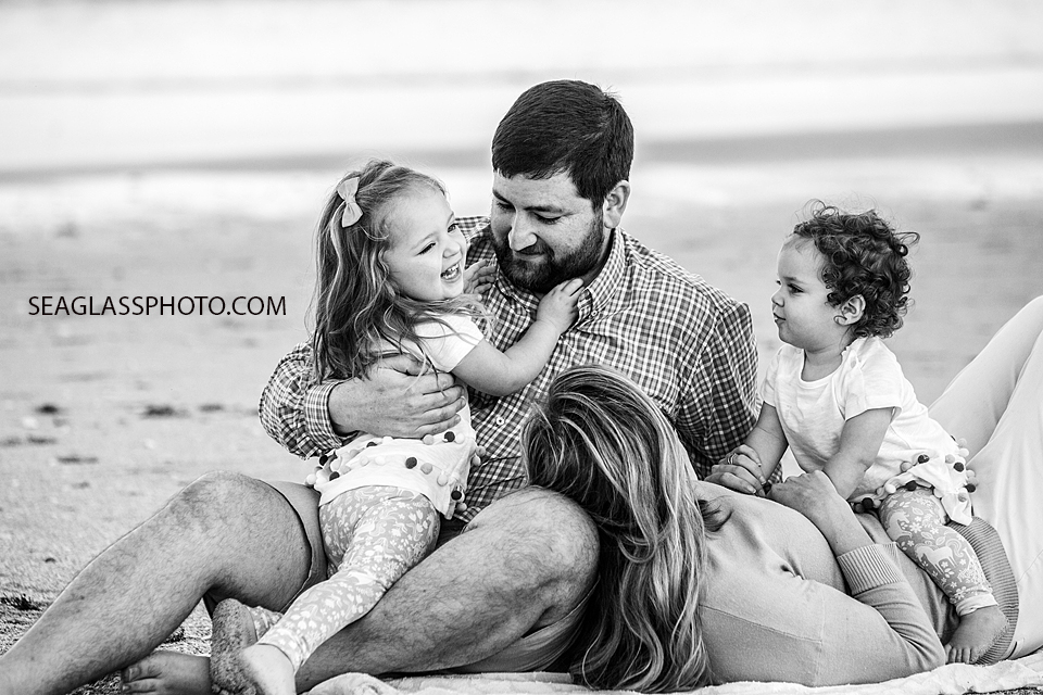 Black and white close up photo of a family laying down on the beach during their family photo shoot in Vero Beach Florida