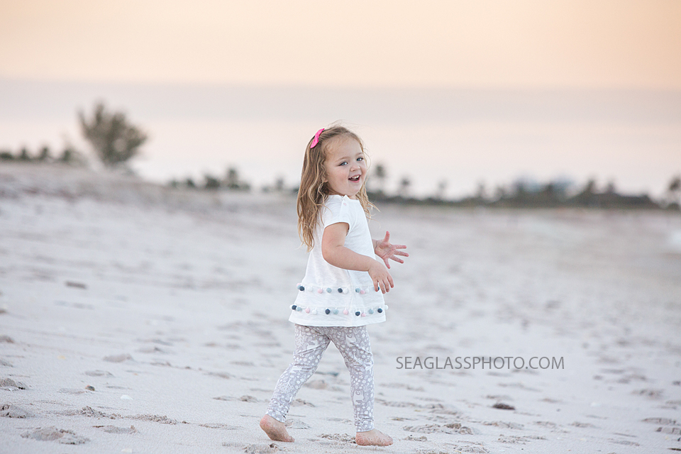 Young girl walks on the beach during their family photo shoot in Vero Beach Florida