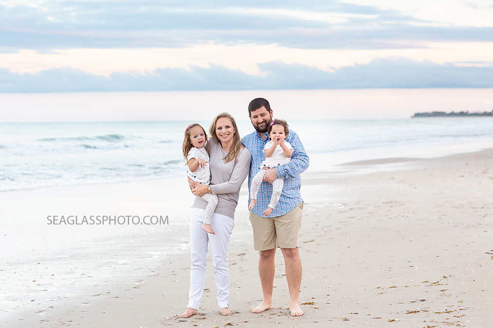 Family smiles for the camera on the beach during their family photo shoot in Vero Beach Florida