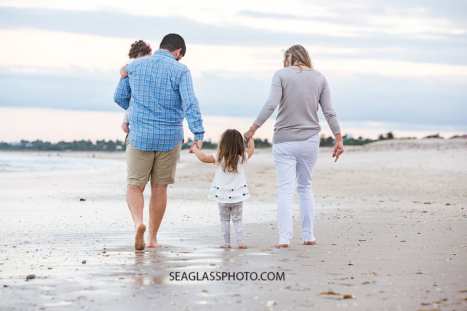 Family walks on the beach during their family photo shoot in Vero Beach Florida