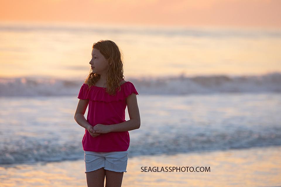 Young girl looks out on the beach during a family photoshoot in Vero Beach Florida