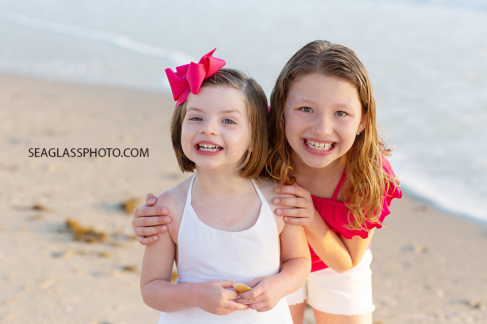 Sisters smile for the camera during a family photoshoot in Vero Beach Florida