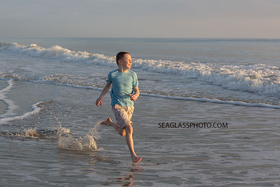 Young boy runs in the water during a family photoshoot in Vero Beach Florida
