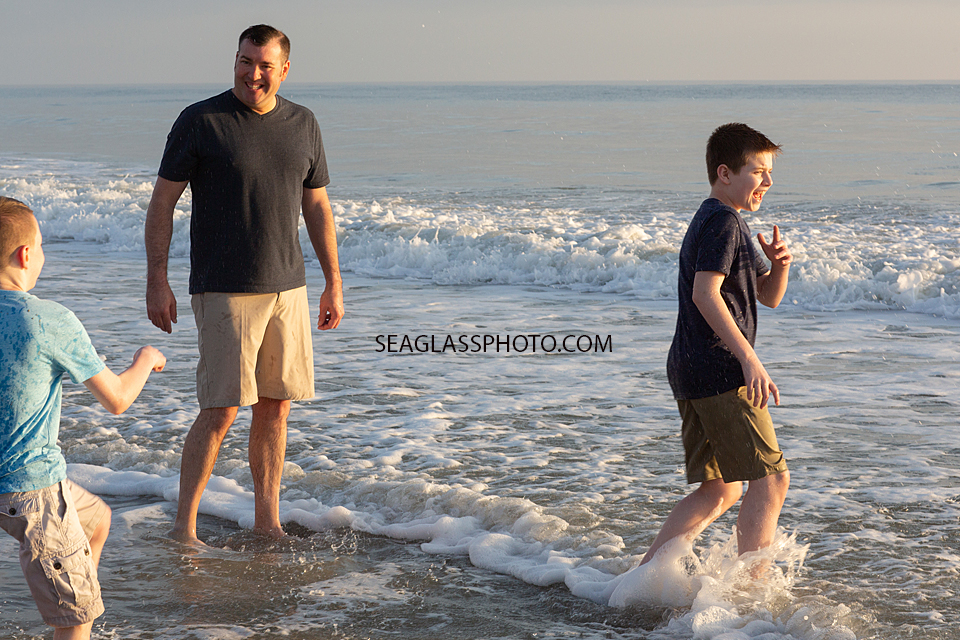 Father and sons hanging out in the ocean during a family photoshoot in Vero Beach Florida