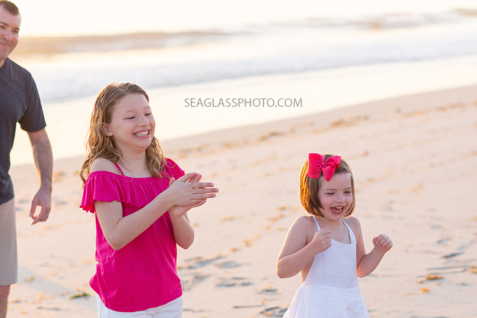young girls clap and smile during a family photoshoot in Vero Beach Florida