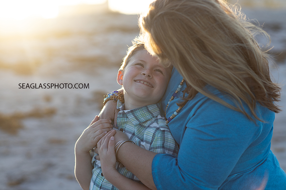 Mom hugs her son while he smiles during a family photoshoot in Vero Beach Florida