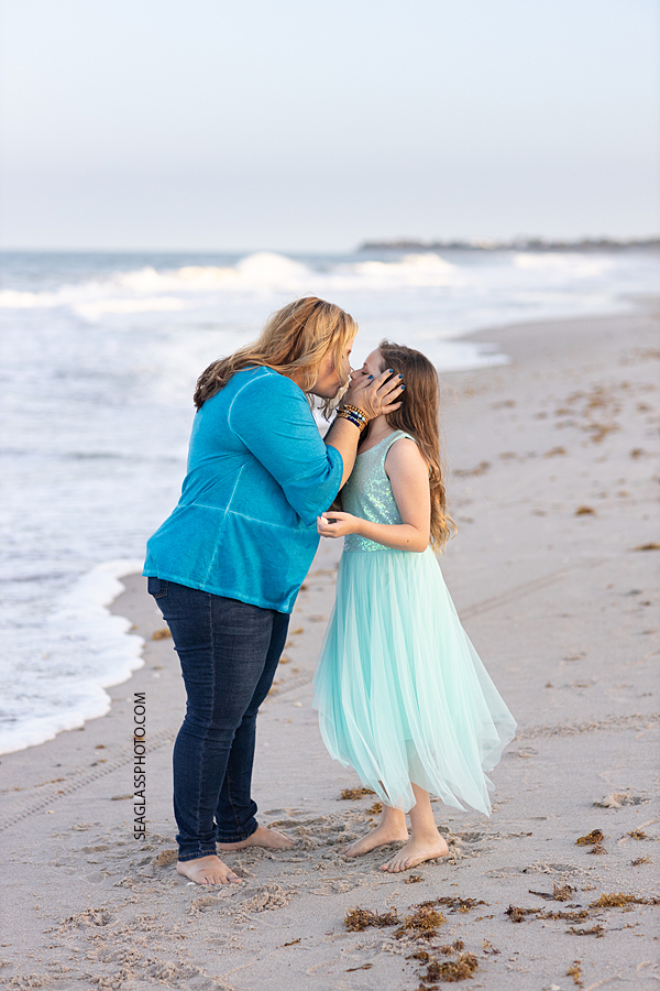 Mother and daughter give each other eskimo kisses on the beach during a family photoshoot in Vero Beach Florida