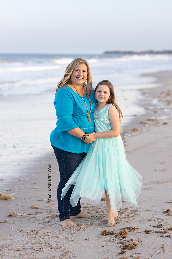Mother and daughter smile for the camera on the beach during a family photoshoot in Vero Beach Florida