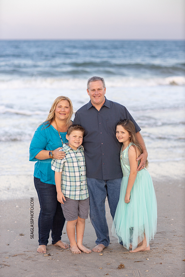 Family of four get close for a family photo during a family photoshoot in Vero Beach Florida