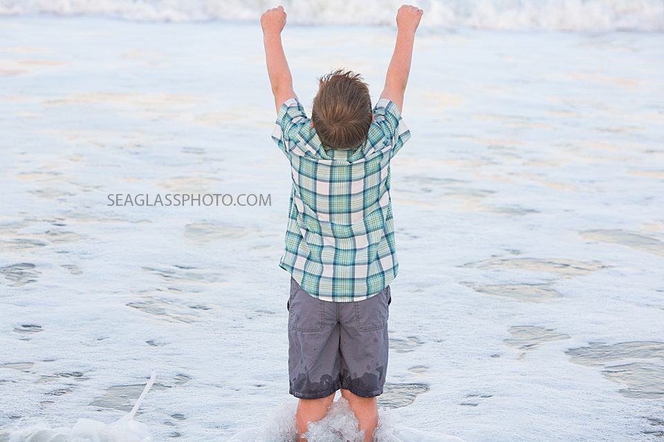 Young boy looks out to the beach during a family photoshoot in Vero Beach Florida