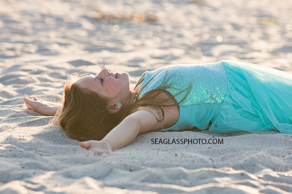 Some times you just need to lay in the sand and look to the sky and take a breather thats exactly what this little girl did during a family photoshoot in Vero Beach Florida