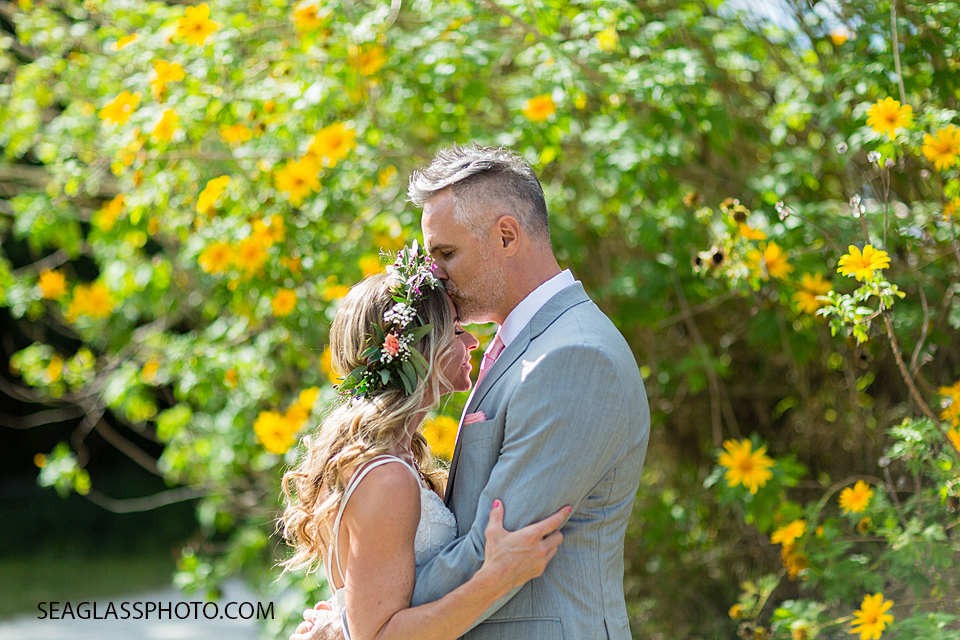 Groom kissing his bride's forehead following their outdoor wedding in Vero Beach Florida