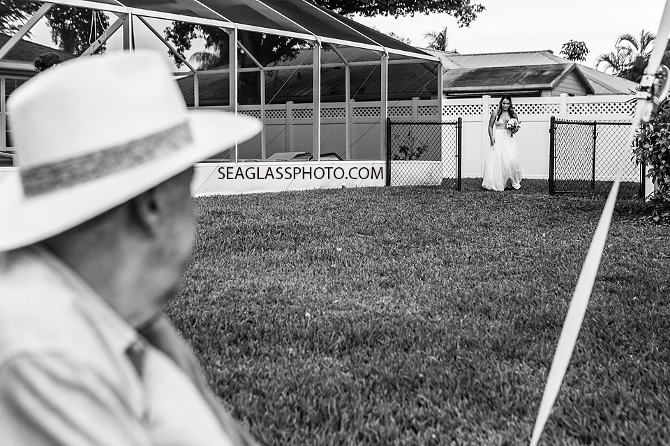 Black and White Father watches his daughter walk towards the wedding in Vero Beach Florida